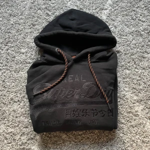 Superdry hoodie - En svart snygg Superdry hoodie i storlek M väldigt bra skick det är bara att skriva vid frågor eller intresse 