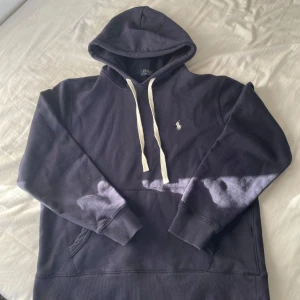 Mörkblå hoodie från Polo Ralph Lauren - Snygg mörkblå hoodie från Polo Ralph Lauren, den är storlek M men passar S. Den är använd men ändå i bra skick. Säljer då den inte passar mig. Skriv för frågor! 🚀