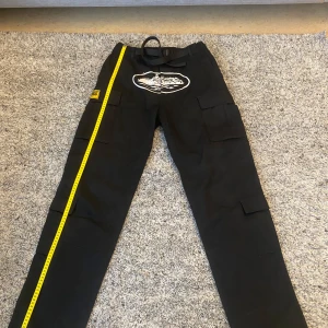 Svarta cargopants från Corteiz - Cargopants från Corteiz i perfekt skick. Storlek XL  (Byxorna är uppvikta nere vid anklarna på bilderna där de sitter på) Finns fler bilder både när de sitter på  och detaljbilder om du vill se mer! :)