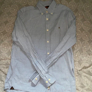 Ljusblå skjorta från Morris - Ljusblå skjorta från Morris i storlek S. Fint skick till ett bra pris. Nypris: 1399kr Mitt pris: 249kr.                     Vid frågor eller funderingar, tveka inte att höra av dig.