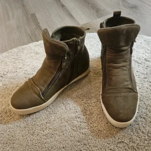 Vinterskor  - Snygga mörkgröna boots i mocka med vit sula och dubbla dragkedjor på sidorna. Skorna har en rund tå och är perfekta för dig som gillar en stilren men ändå cool look. Passar till många outfits och är riktigt bekväma att bära.