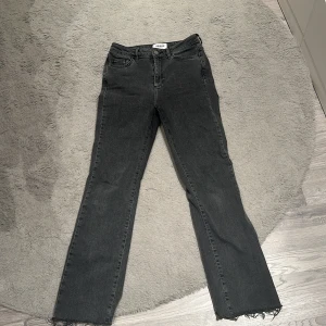 Svarta bootcut jeans från Aware - Svarta jeans från Aware med bootcut passform och råa, fransiga benslut. Klassisk femficksmodell med hög midja och dragkedja. Jeansen är i ett mjukt denimtyg som ger en avslappnad vibe och passar perfekt till sneakers eller boots. Storlek 28/32🥰