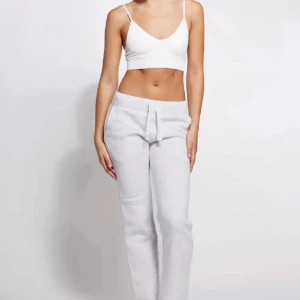 Grå russemerch  - Superbekväma ljusgrå russemerch mjukisbyxor med rak passform och snörning i midjan. Perfekta för chill dagar eller när du vill ha en avslappnad stil. Tillverkade i mjukt bomullsmaterial som känns skönt mot huden.