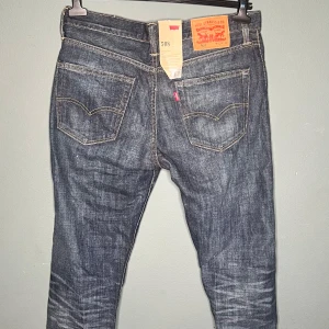 Levi's 508 jeans blå W32 L32 - Säljer ett par Levi's 508 jeans i klassisk blå denim med snygga slitningar och kontrastsömmar. Modellen har fem fickor, normal passform och raka ben. Perfekta för dig som gillar en tidlös jeansstil.