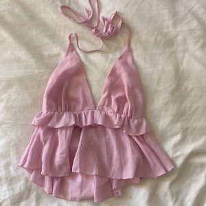 Rosa volangig linnetopp med knytband - Supersöt stretchig tröja som man knyter runt halsen, med öppen rygg🙏💘endast använd 1 gång.