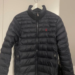 Ralph Lauren dunjacka - Säljer denna feta mörkblåa Ralph Lauren dunjacka. Jackan är i storlek S och i mycket bra skick. Den är perfekt nu till hösten. Nypris är 4295kr. Hör av er om ni är intresserade!