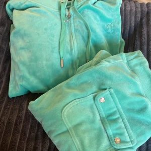 Turkosa mjukisbyxor Juicy Couture XXS - Ett turkost sätt från Juciy Couture! Byxorna är i storlek XXS och tröjan är i stolek S. De är som nytt och använt ungefär 2-3 gånger, säljer då det inte är min typ av färg. Vill ni ha fler bilder så kontakta mig, skriv om ni är intresserade innan ni trycker på ”KÖP NU” ❤️Pris kan diskuteras, just nu ligger det på 1800kr för hela sättet, ej styckpris.