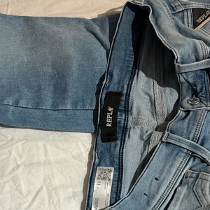 Replay Anbass ljusblå jeans - Säljer ett par Replay Anbass Hyperflex jeans i ljusblå tvätt. Klassisk femficksmodell med snygga detaljer på bakfickorna och läderpatch i midjan. Jeansen är raka i modellen och har en bekväm stretchig känsla. Tecken på användning men mycket bra skick