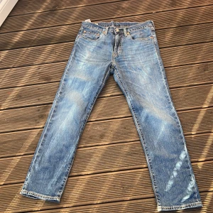 Levi's 502 blå jeans straight/slim fit - Klassiska blå Levi's 502 jeans med straight fit och normal passform. Jeansen har fem fickor, snygga slitningar och den ikoniska läderpatchen bak i midjan. Perfekta för dig som gillar en tidlös look och vill ha ett par jeans som funkar till allt. Det är Wide 31 Leight 30.