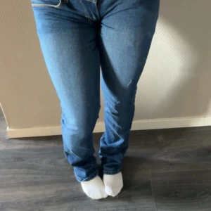 Blå bootcut jeans med dödskalleknapp - Super lågmidjade jeans från ceap Monday. Storlek 36 och stämmer bra enligt mig! De är även om sydda till mycket lågmidjat och vill man kan man sprätta upp de❤️Snygga blå jeans med bootcut passform och klassiska gula sömmar. 