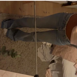 Ljusblå bootcut jeans med låg midja - Säljer ett par ljusblå jeans med bootcut-modell och låg midja. Jeansen har klassisk femficksdesign, dragkedja och knapp framtill. Perfekta för dig som gillar en retro vibe och vill ha ett par snygga jeans med utsvängda ben.