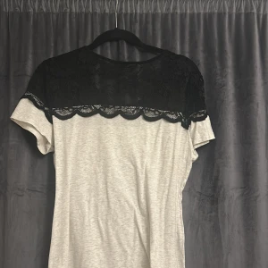 Spets t-shirt - Snygg grå topp med korta ärmar och svart spets.🍸