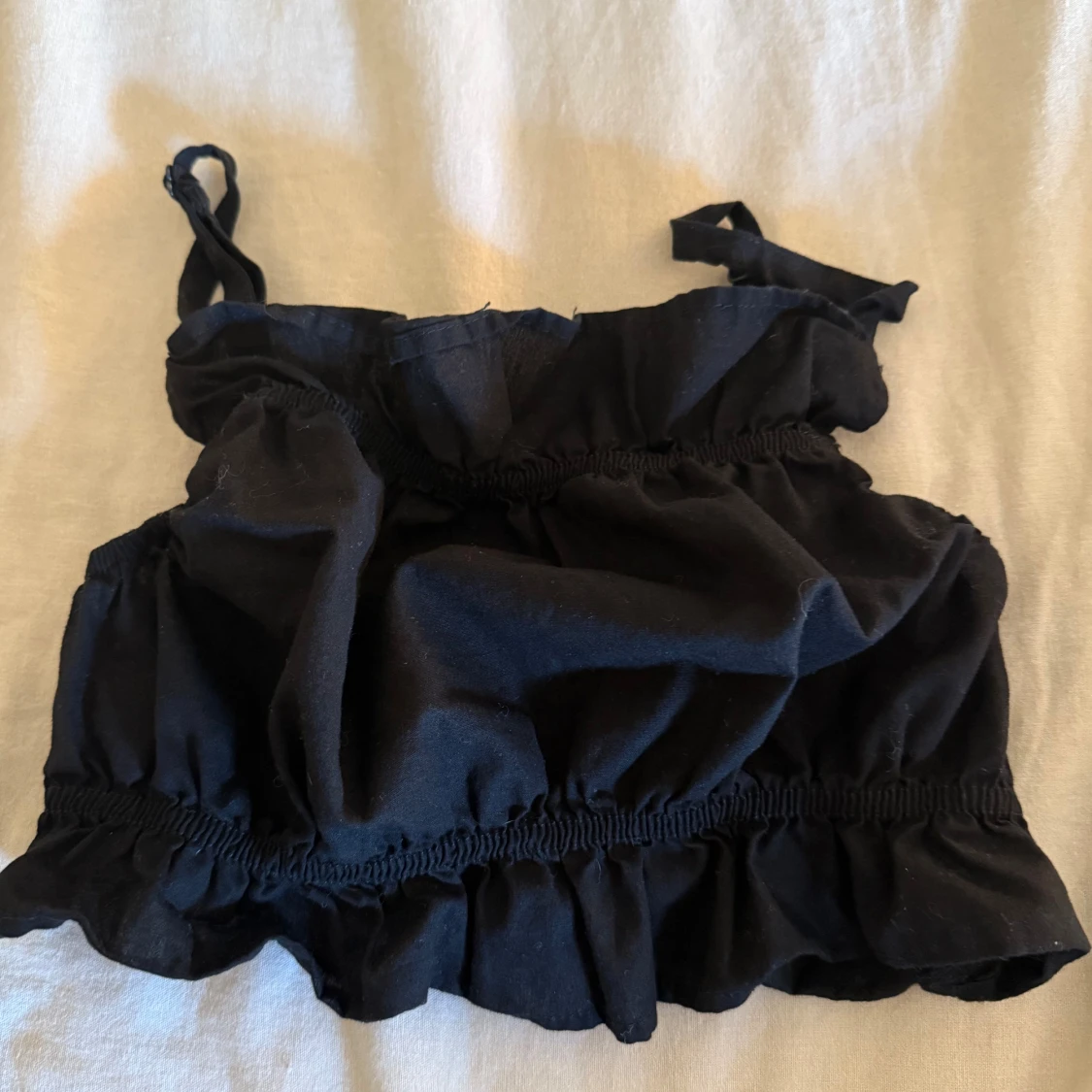 Svart volangig linnetopp från Divided