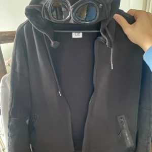 C.P Company zip hoodie - Säljer nu min sjukt snygga cp company zip hoodie som är perfekt för dig som gillar att sticka ut. Köpt för 3600 på Wonder i varberg. Köpt för ca 1 års sedan men använt i våras typ sen hängt:) 