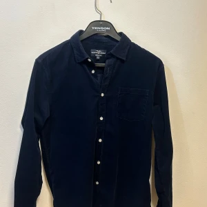 Mörkblå manchesterskjorta Hampton Republic - Snygg mörkblå manchesterskjorta från Hampton Republic. Knappt använd och självklart fri från skador och fläckar. En strykning och den är som ny. 