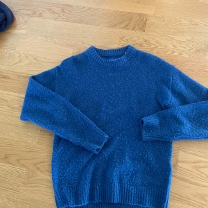 Blå stickad tröja från Jack & Jones XS - Mysig blå stickad tröja från Jack & Jones i storlek XS. Tröjan har rund halsringning, ribbade muddar och är långärmad. Perfekt för kyliga dagar och enkel att matcha med jeans eller kjol.