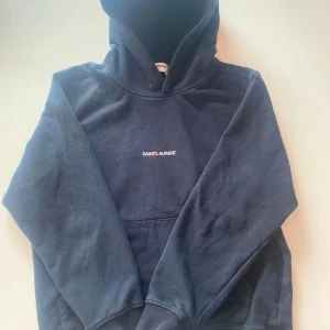 Saint Laurent Hoodie - Snygg svart hoodie från Saint Laurent. Priset är ej satt i sten. Perfekt för en stilren och avslappnad look. Bara att fråga om du undrar något. Det saknas dragsträngar och därför säljs den för ett rimligt pris.