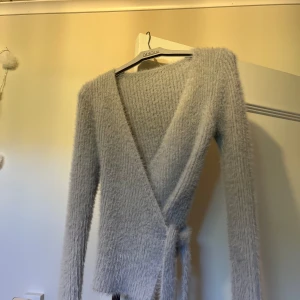 Blå stickad omlottströja🩵 - Vet inte vart den är ifrån. Skulle säga att den är i storlek XS då den sitter tajt beroende på hur mycket man justerar🤗