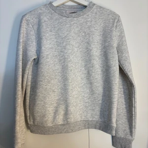 Grå sweatshirt - En stilren grå sweatshirt med rund hals och långa ärmar från Nelly.