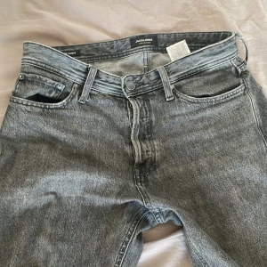 Gråa relaxed jeans från Jack & Jones 31/32 - Säljer ett par gråa jeans från Jack & Jones i modellen Relaxed/Chris. Jeansen har en avslappnad passform, klassisk femficksdesign och är tillverkade i tvättad denim. Perfekta för dig som gillar en bekväm stil.