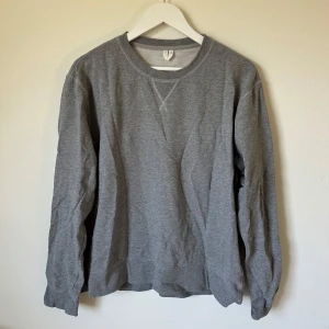 Grå sweatshirt från Arket, storlek L - En stilren grå sweatshirt från Arket i storlek L. Tröjan har rund halsringning, långa ärmar och är tillverkad i mjuk bomull. Perfekt basic-plagg med klassisk passform och ribbade muddar vid ärmslut och nederkant. 2L5