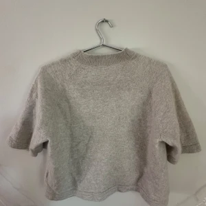 Beige stickad tröja & Other Stories - Supermjuk och stickad beige tröja från & Other Stories med korta ärmar och ribbad halsringning. Perfekt för lager-på-lager och har en avslappnad, boxig passform. Enkel att styla till både jeans och kjol. Storlek XS men kan också funka som S! 💗💗