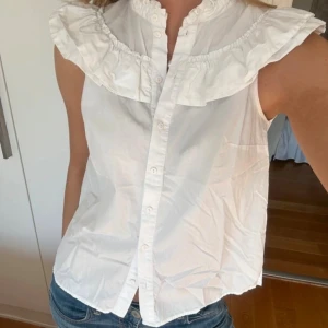 Vit ärmlös blus med volangkrage - Supersöt vit blus med volangkrage från hm.