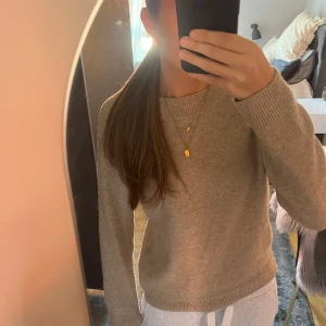 Beige stickad tröja från ONLY - Mysig beige stickad tröja från ONLY med rund halsringning och ribbade muddar. Perfekt för lager-på-lager och passar till allt. Enkel och stilren design som är lätt att matcha med både jeans och mjukisbyxor.