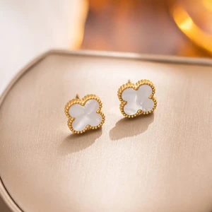 Guldfärgad örhängen med vit blomform - Snygga örhängen i guldton med vit blomformad detalj. Kanter med små guldfärgade pärlor ger en lyxig känsla. Perfekta för att lyfta din look med en elegant touch.