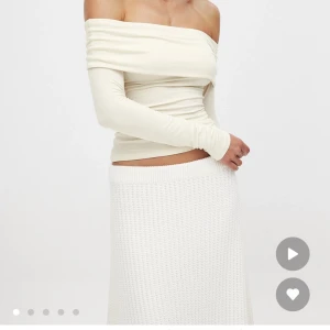 Offshoulder cremefärgad topp - Trendig offshoulder topp i cremevitt med långa ärmar och figurnära passform. Toppens material är mjukt och stretchigt, vilket ger en snygg drapering över axlarna. Perfekt för dig som gillar en stilren och chic look.