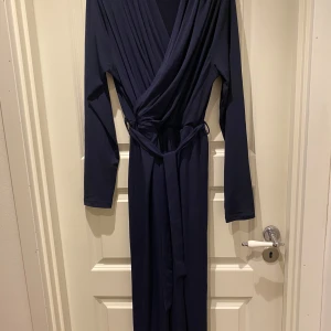 Marinblå omlottklänning Islamic Wear - Snygg marinblå abaya från Islamic Wear med omlott-design och v-ringad hals. Köpt i Köpenhamn. Står storlek 5, men passar XS-M