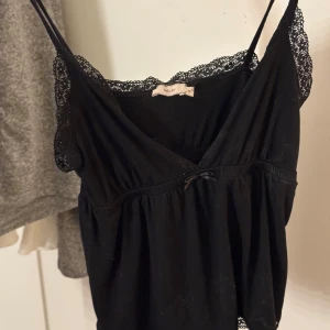Svart linne från Nelly - Säljer ett svart linne från Nelly med spetsdetaljer
