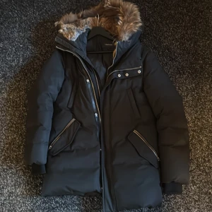 Mackage Edward - Säljer min exklusiva Mackage Edward herrjacka i storlek 38 (motsvarar M). Jackan är i mycket fint skick, varm och stilren med klassisk Mackage-design.  ✅ Äkta päls på huvan (avtagbar) ✅ Fyllning: högkvalitativt dun → extremt varm även i kalla vintrar ✅ Färg: svart ✅ Nypris: ca 15 000 kr ✅ Passar dig som vill ha en lyxig vinterjacka som håller många säsonger 