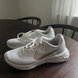 Vita Nike sneakers strl 37.5 - Vita sneakers från Nike. Endast använd fåtal gånger inomhus. Finns lite slitage men i helhet väldigt bra skick