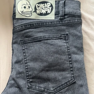 Grå/svarta Cheap Monday jeans - Säljer ett par grå/svarta jeans från Cheap Monday med snyggt Cheap Monday-märke bak. Jeansen har en rak/flare passform och sitter skönt.😊