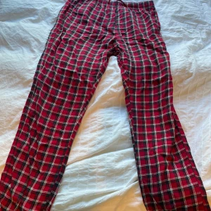 Rödrutiga pyjamasbyxor från H&M, stl S - Rödrutiga byxor från H&M i mjuk bomull. Klassisk rutig design i rött, svart och vitt med elastisk midja för extra komfort. Perfekta för chill dagar hemma eller när du vill ha en avslappnad look.