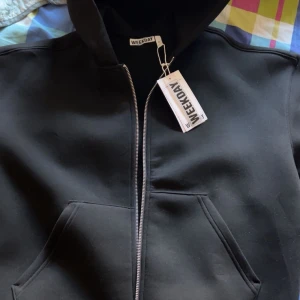 Svart hoodie med dragkedja från Weekday - Säljer en svart hoodie från Weekday med huva och grov dragkedja framtill. Tröjan har en loose passform, stora fickor och är tillverkad i mjuk bomullsmix. Perfekt för dig som gillar stilrena och enkla plagg med streetkänsla.