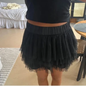 Svart volangkjol i tyll, storlek 36 - Supersöt svart kortkjol med flera lager volanger i tyll. 