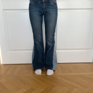 Blå bootcut jeans Norah, stl 26/32 - Snygga blå bootcut jeans från Norah med klassisk femficksdesign och kontrastsömmar. Jeansen har en mörk tvätt och utsvängda ben, vilket ger en retrovibe. Tillverkade i jeansmaterial och perfekta för dig som gillar en avslappnad men trendig look. Perfekt för dig mellan 158-163cm💕💕