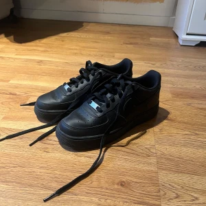 Nike Air Force 1 - Nike Air Force 1’s i svart, använda 1-2 gånger. Legat i garderoben och förvarats i mycket bra skick, inga tecken på skador eller slit!