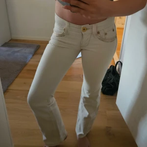 Vita jeans - Vita jeans från River Island med fina guld och silverdetaljer och lite gulddetaljer i materialet💕 storleken är lite oklar men passar xs eller xxs och är perfekt för mig i längden som är 162 cm🩷 lånade bilder från förra säljaren då dem va precis för små för mig, pris kan diskuteras 