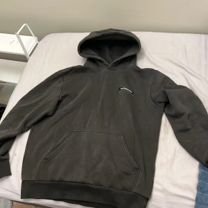 Mörkgrå hoodie från Peak Performance - Säljer en stilren mörkgrå hoodie från Peak Performance med klassisk logga på bröstet. Tröjan har huva, känguruficka och ribbade muddar. Perfekt för dig som gillar en clean och avslappnad look.