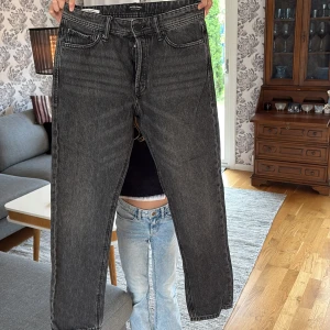 Svarta jeans Jack & Jones - Tjena! Säljer ett par otroligt fina Jack N Jones jeans som är i väldigt fint skick. Ingen skada på dem, storlek 30/32 och modell Loose fit/chris vilket innebär att de sitter lite mer loose än regualar men fortfarande inte helt loose. Skriv vid minsta fundering!🙌🏼🙌🏼