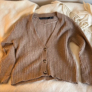 Brun mysig kofta - Brun kofta men knappar där bak. V-ringning. Varmt material som passar på höst och vinter. 