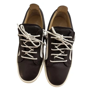 Giuseppe Zanotti skor - Snygga bruna sneakers från Giuseppe Zanotti i skinn med vita detaljer och vita snören. Skorna är i extremt bra skick och självklart äkta. Vid minsta fundering är det bara att skriva 