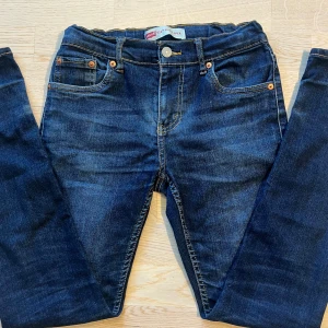 Mörkblå Levi's 512 Slim jeans  - Säljer ett par mörkblå Levi's 512 Slim jeans . Dem är i storlek 164 men passar även dem som är lite längre. Modellen är ca 169 cm. Jeansen har smal passform med avsmalnande ben. Skick: 7/10 ✅ Dem har märken från uppvikning längst ner. Tveka inte på att höra av dig vid funderingar!