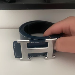 Ett mörkblått bälte med ett silvrigt spänne - Säljer ett helt nytt bälte inte använt en ända gång storlek 115 kan förhandla priset