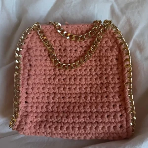 Stella maccartney liknande väska  - Superfin handgjord axelväska i virkad rosa bomull med chunky guldfärgad kedja som axelrem och detalj runt kanterna. Använd fåtal gånger.OBS bilderna är lånade från den jag köpte väskan av.