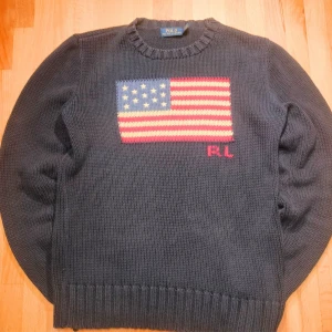 Polo Ralph Lauren USA Sweater 90s med USA-flagga🇺🇸 - Säljer en ikonisk Polo Ralph Lauren stickad tröja med den klassiska USA-flaggan framtill. Storlek S och i riktigt fint skick, nästan som ny! Nypriset ligger runt 5000 kr, mitt pris är 1199 kr och pris kan diskuteras vid snabb affär 🤝  Perfekt för dig som älskar old money / 90s heritage-stilen eller vill lyfta en enkel outfit med en äkta klassiker. Tjock, mjuk och kvalitén är vad man förväntar sig av Polo – håller i många år till.  📦 Skickar snabbt 🙂 Fråga gärna om mått eller fler bilder 🧼 Fräsch