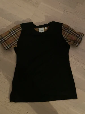 Äkta burberry t shirt - Äkta burberry t shirt för bra pris, storlek M i barn storlek=ungefär 155-165. Jättebra skick och passar perfekt med svarta jeans!